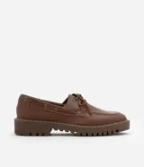 Zapato estilo dockside de cuero color marrón, con puntera redonda, cordones frontales y suela track dentada.