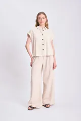 Pantalón de lino color crudo, de corte palazzo y tiro alto.