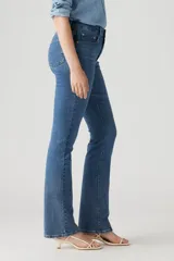 Pantalón de jean azul de tiro alto, ajustado en cadera y muslos, con pierna acampanada.