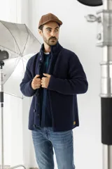 Sweater de punto grueso color azul marino, con cuello alto y cierre frontal de botones.