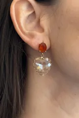 Caravanas colgantes con diseño de corazón de cristal transparente facetado y piedra superior ovalada color naranja rojizo, montadas en base dorada.