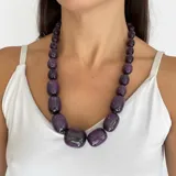Collar de cuentas tubulares de resina brillante con efecto degradé en tonos azules y vetas marrones. Presenta un diseño voluminoso y cierre de rosca.