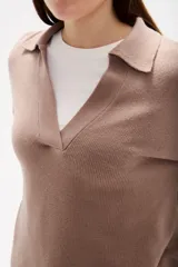 Sweater de punto color azul, con cuello polo y escote en V, de manga larga y diseño holgado.