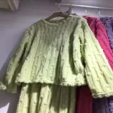 Pijama de dos piezas de tejido plush texturado con diseño de puntos en relieve, compuesto por un buzo de manga larga con cuello redondo y un pantalón largo de corte recto.