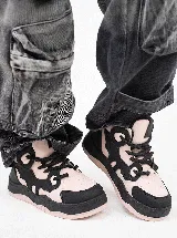 Championes de estilo skate con plataforma, combinando paneles en color rosa claro y negro. Presentan un diseño con cordones gruesos negros y suela de plataforma en dos tonos.