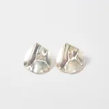 Caravanas de diseño irregular con acabado metálico plateado y textura rugosa.