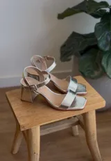 Sandalias de taco cuadrado bajo en color plateado, con diseño de punta cuadrada y tira ajustable con hebilla en el tobillo.