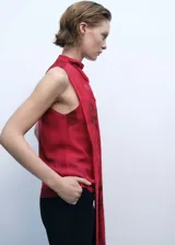 Blusa roja con estampado floral, cuello drapeado y fular, sin mangas, con forro interior y cierre de botón en la parte posterior. Prenda de gasa perteneciente a la colección de evento.
