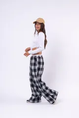 Pantalon de corte amplio y tiro bajo, confeccionado en tela de franela con estampado de cuadros en tonos blanco, negro y gris. Cuenta con cintura elástica con cordón ajustable y bolsillos laterales.