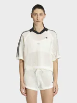 Polo de crochet color blanco con cuello polo negro en V, mangas cortas con las icónicas tres tiras de Adidas en negro y logo de la marca bordado en el pecho.