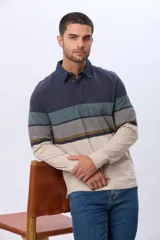 Remera polo de manga larga confeccionada en algodón con diseño de franjas horizontales en tonos azul marino, verde militar, gris, mostaza y beige. Cuenta con cuello camisero y cierre frontal parcial con botones.