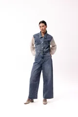 Campera de jean negra con mangas largas tejidas en crochet con diseño calado y detalles florales en relieve. Presenta cuello camisero, cierre frontal y bolsillos en el pecho.