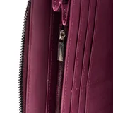 Billetera tipo fichero grande marca XL, confeccionada en material sintético texturizado color lila. Cuenta con cierre perimetral, logo metálico frontal y correa de muñeca extraíble.