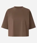 Remera cropped de manga corta, cuello redondo y calce oversized, confeccionada en tejido de algodón tipo media malla.