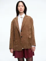 Blazer de pana color marrón con solapas clásicas, cierre frontal de dos botones y bolsillos laterales con solapa.