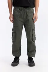 Pantalón cargo verde militar de corte amplio, con cintura elástica y cordón ajustable, bolsillos laterales con tapa y puños elastizados.