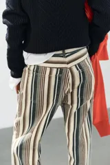 Jeans de tiro medio con diseño de rayas verticales en tonos beige, marrón y verde, corte boyfriend, cinco bolsillos y cierre frontal con cremallera y botón.