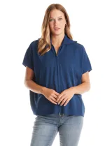 Cardigan de punto azul, con cierre frontal metálico completo, cuello con solapa y mangas cortas de sisa caída. Presenta un corte recto y holgado.