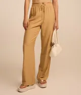 Conjunto de top bandeau y pantalón fluido de viscosa color beige con rayas verticales blancas.