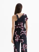 Top asimétrico confeccionado en popelina 4way con estampado exclusivo de dragones y flores. Un lateral tiene bretel fino y el otro manga corta, creando un efecto de un solo hombro cubierto.