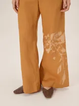Pantalón de lino color azul metalizado, de corte sastrero, tiro medio y pierna recta amplia.