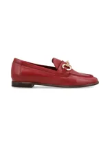 Mocasines de cuero rojo con herraje metálico dorado en el empeine, suela plana y costuras visibles.