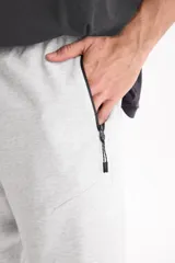 Bermuda de felpa sin friza de color negro, con cintura elastizada, cordón ajustable y bolsillos laterales con cierre. Presenta un pequeño logo estampado en el borde inferior.