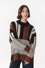Buzo de tejido de punto con diseño de bloques de rayas verticales y horizontales en tonos negro, beige y marrón. Presenta cuello alto, corte oversize y terminaciones en rib en puños y ruedo.