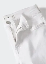 Jeans skinny de tiro bajo en color blanco, con diseño de cinco bolsillos, trabillas para cinturón y cierre frontal con cremallera y botón.