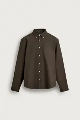 Camisa de manga larga regular fit en color marrón oscuro, confeccionada en tejido de algodón. Presenta cuello abotonado, bolsillo de parche en el pecho y cierre frontal con botones en contraste.