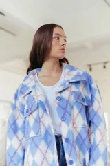 Camisa larga con estampado de rombos en tonos celeste, blanco y rosa. Tiene cuello camisero, cierre con botones y bolsillos frontales.