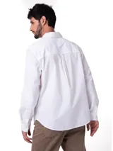 Camisa de manga larga blanca de popelina de algodón, de corte clásico con cuello camisero, cierre frontal con botones y bolsillo en el pecho con etiqueta de la marca.