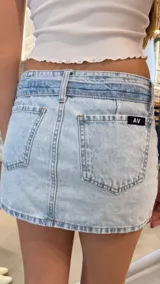 Minifalda de denim tiro bajo con cinturón incorporado y detalle de costuras verticales.