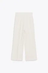 Pantalón tipo culotte de tiro alto, pierna ancha y pinzas frontales. Color beige/topo liso.