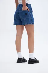 Short de jean azul, tiro alto con calce holgado en cadera y detalle de bolsillos amplios.