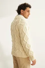 Sweater de lana color beige, tejido a mano con ochos y cuello cruzado. Terminaciones en punto elástico en puños y ruedos.