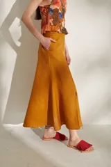 Pollera larga azul de tiro alto, con botonadura frontal y aberturas en el bajo.