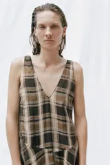 Vestido midi de escote en V y tirantes anchos, con bajo asimétrico y estampado de cuadros en tonos marrones, negros y beige.