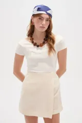 Top de viscosa blanco, de corte entallado, mangas cortas y cuello bote.