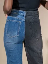 Pantalón de jean de tiro alto, una pierna de denim azul con roturas en la rodilla y la otra pierna dorada con efecto lamé y roturas en la rodilla.
