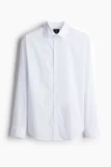 Camisa blanca de manga larga, corte slim fit, confeccionada en tejido elástico de mezcla de algodón. Presenta cuello italiano, tapeta lisa con botones y puños ajustables con botón.