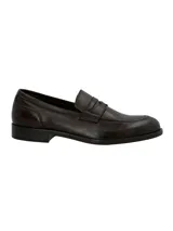 Mocasín estilo penny loafer para hombre, confeccionado en cuero marrón oscuro con textura sutil, punta redonda y suela plana con pequeño tacón.