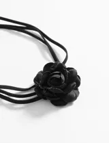 Collar tipo choker negro con diseño de flor central de tela y tiras finas ajustables mediante lazo.