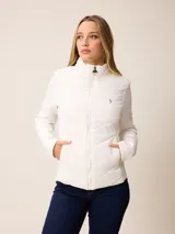 Campera acolchada con frente y espalda en tejido técnico, combinada con mangas y laterales de tejido liso. Presenta cuello alto, cierre frontal completo y bolsillos laterales. Incluye un pequeño detalle bordado en el pecho.