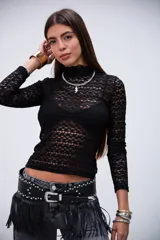 Remera negra de manga larga con cuello alto y tejido de encaje transparente.