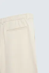 Bermuda de hombre color verde claro, de corte regular y tiro medio, con pinzas frontales, bolsillos laterales y bolsillos traseros de vivo. Cierre frontal con botón y cremallera.