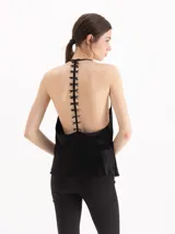 Top de satín negro con escote drapeado y tirantes finos tipo halter.