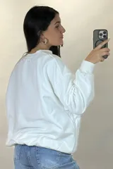 Buzo de cuello redondo, corte oversize, con mangas largas y puños elásticos.