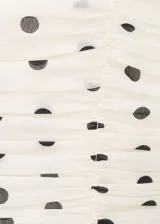 Top de tirantes finos color blanco con estampado de lunares negros, diseño fruncido y escote recto.