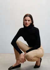 Leggings de efecto gamuza en color beige, con diseño ajustado, costuras frontales verticales y cierre lateral en el bajo.